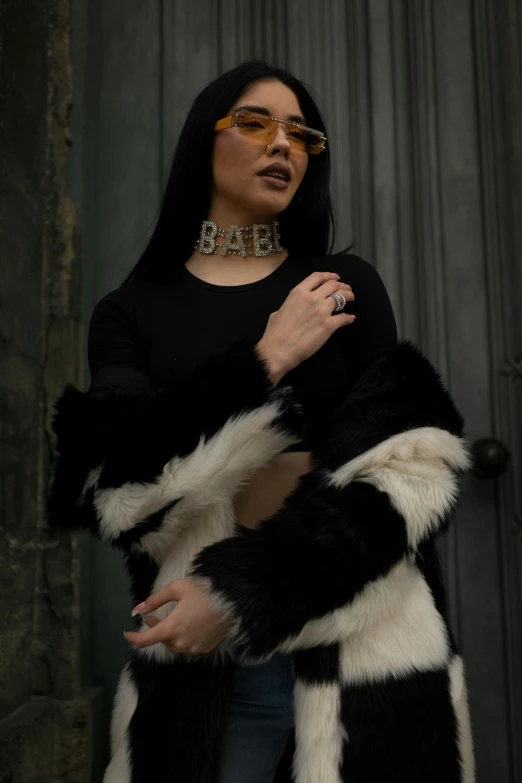 a woman wearing a black and white fur coat, inspired by Elsa Bleda, featured on reddit, rapper bling jewelry, bella poarch, wearing gold detailed choker, high quality photo