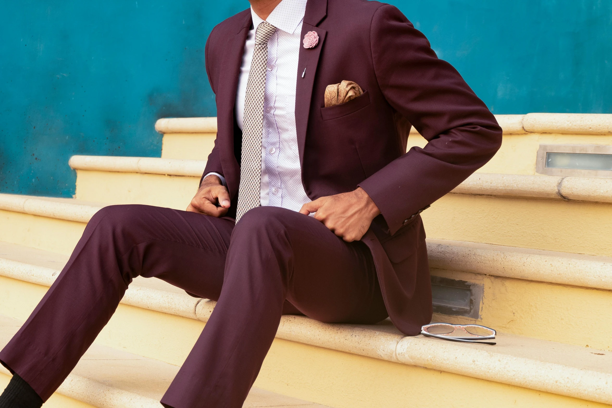 a man in a suit sitting on some steps, trending on pexels, renaissance, brown and magenta color scheme, maroon and white, elegant suit, sunday afternoon