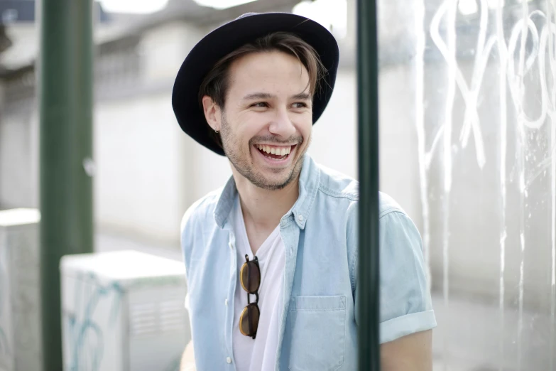 a man with a hat and a tie smiling