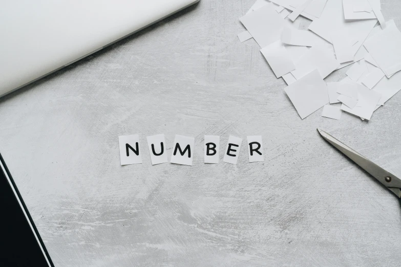 a pair of scissors sitting on top of a table, sacred numbers, concrete poetry, background image, minimalist desk