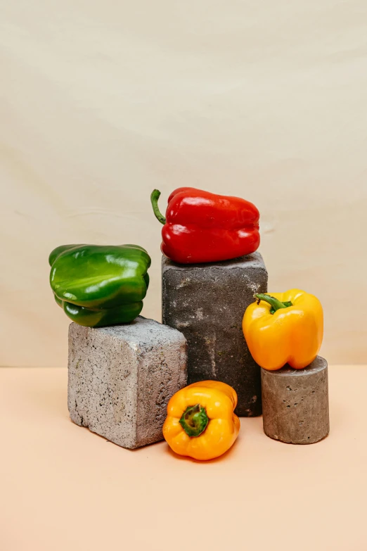 a group of peppers sitting on top of cement blocks, inspired by Fernando Botero, concrete art, sustainable materials, product shot, multicolored, side profile shot