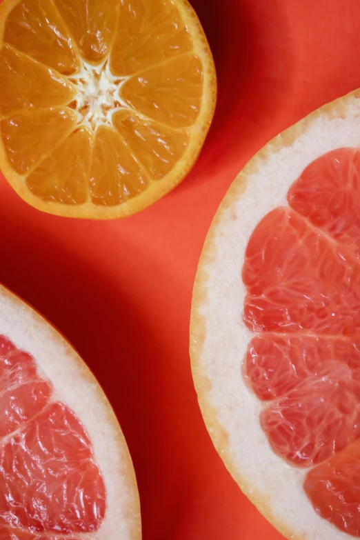 a close up of a grapefruit cut in half, an album cover, bright colors with red hues, mid - shot, pictured from the shoulders up, high light on the left