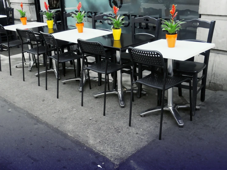 a black and white photo of a table and chairs, by Bernie D’Andrea, pexels, plasticien, un restaurant avec une terrasse, contrasting colours, sidewalk, black furniture