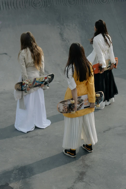 a group of girls standing next to each other holding skateboards, inspired by Modest Urgell, renaissance, wearing off - white style, brutalist fashion show, zoomed out, wearing hakama