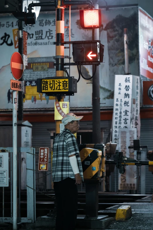 a man standing next to a traffic light at night