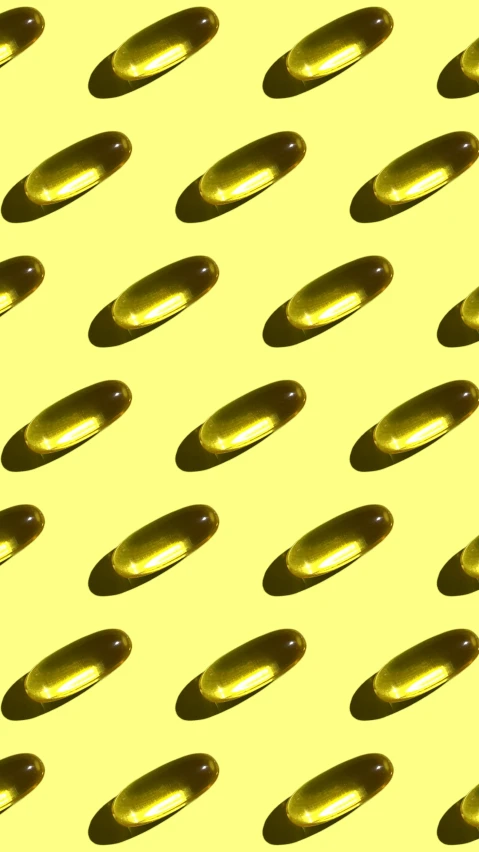 a lot of brown pills sitting on top of a yellow surface, an illustration of, by Carey Morris, pexels, olive oil, wavy, digitally enhanced, fish
