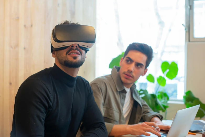 a couple of men sitting at a table with a laptop, a computer rendering, trending on pexels, renaissance, vr goggles, avatar image, cardboard