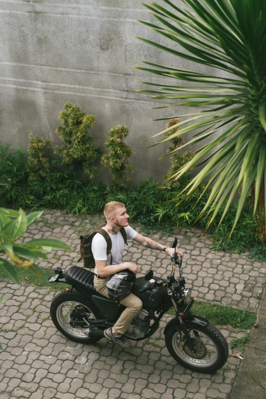 a man riding on the back of a motorcycle, unsplash, sumatraism, amongst foliage, a blond, university, color footage