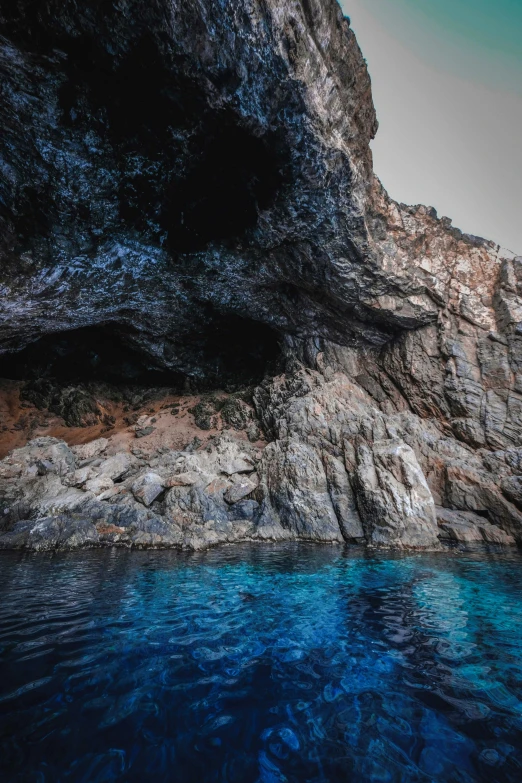 there is a rock cliff that has some blue water