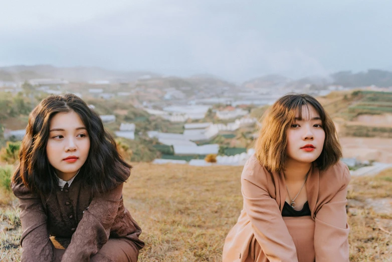 two young women pose for a po in front of an urban view