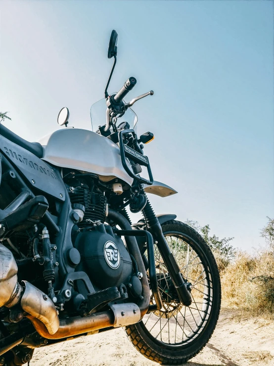 a motorcycle parked on the side of a dirt road, pexels contest winner, white mechanical details, indian super model, on clear background, adventure