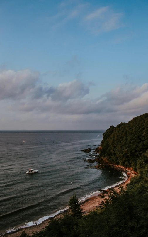 a large body of water sitting on top of a lush green hillside, by Carey Morris, pexels, japan shonan enoshima, late summer evening, ultrawide angle cinematic view, conde nast traveler photo