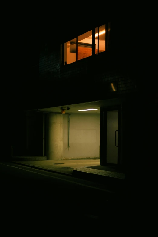 a dimly lit house with one window lit up at night