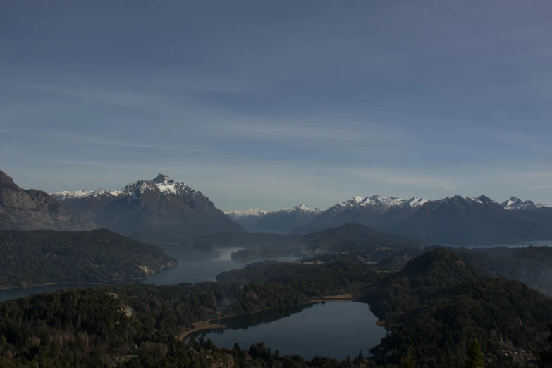 a lake surrounded by mountains and a forest