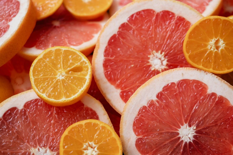 a pile of sliced grapefruits sitting on top of each other, by Carey Morris, pexels, pink and orange, 🦩🪐🐞👩🏻🦳, epicurious, lemon