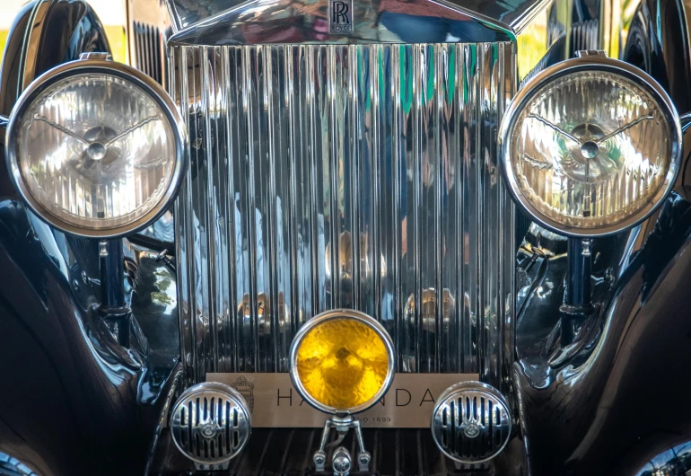 a close up of the front of a vintage car, by Jan Rustem, sparkling in the sunlight, shiny metal, medium wide front shot, art-deco