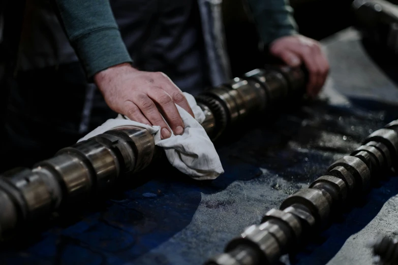 a close up of a person wiping a piece of metal, engines, profile image, holding a staff, perfect scene