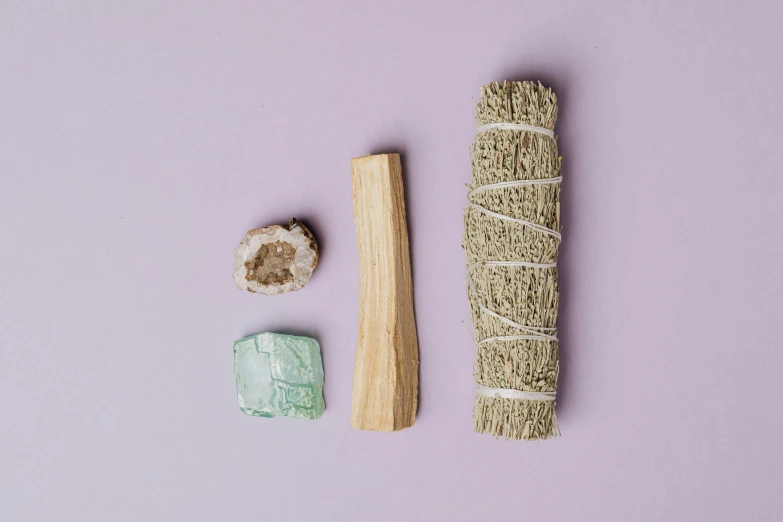 a smudger, a smudger, and a rock on a purple background, a still life, trending on pexels, dau-al-set, sage green, ceremonial ritual, aquamarine, kit