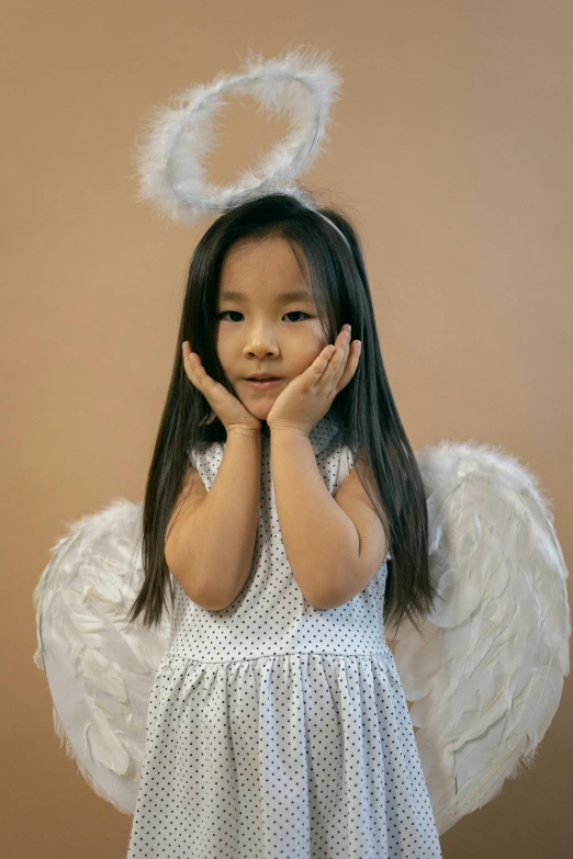 a little girl dressed up as an angel, inspired by Marie Angel, pexels contest winner, young asian girl, slightly - pointed ears, high quality photo, lucifer