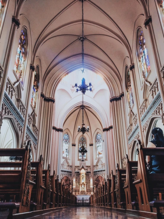 the inside of a church with pews and stained glass windows, a photo, unsplash contest winner, dry archways and spires, trending on vsco, majestic saint woman, photo taken on fujifilm superia