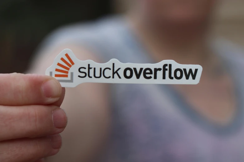 a person holding a sticker that says stuck overflow, flow visualization, thumbnail, exterior shot, avatar image