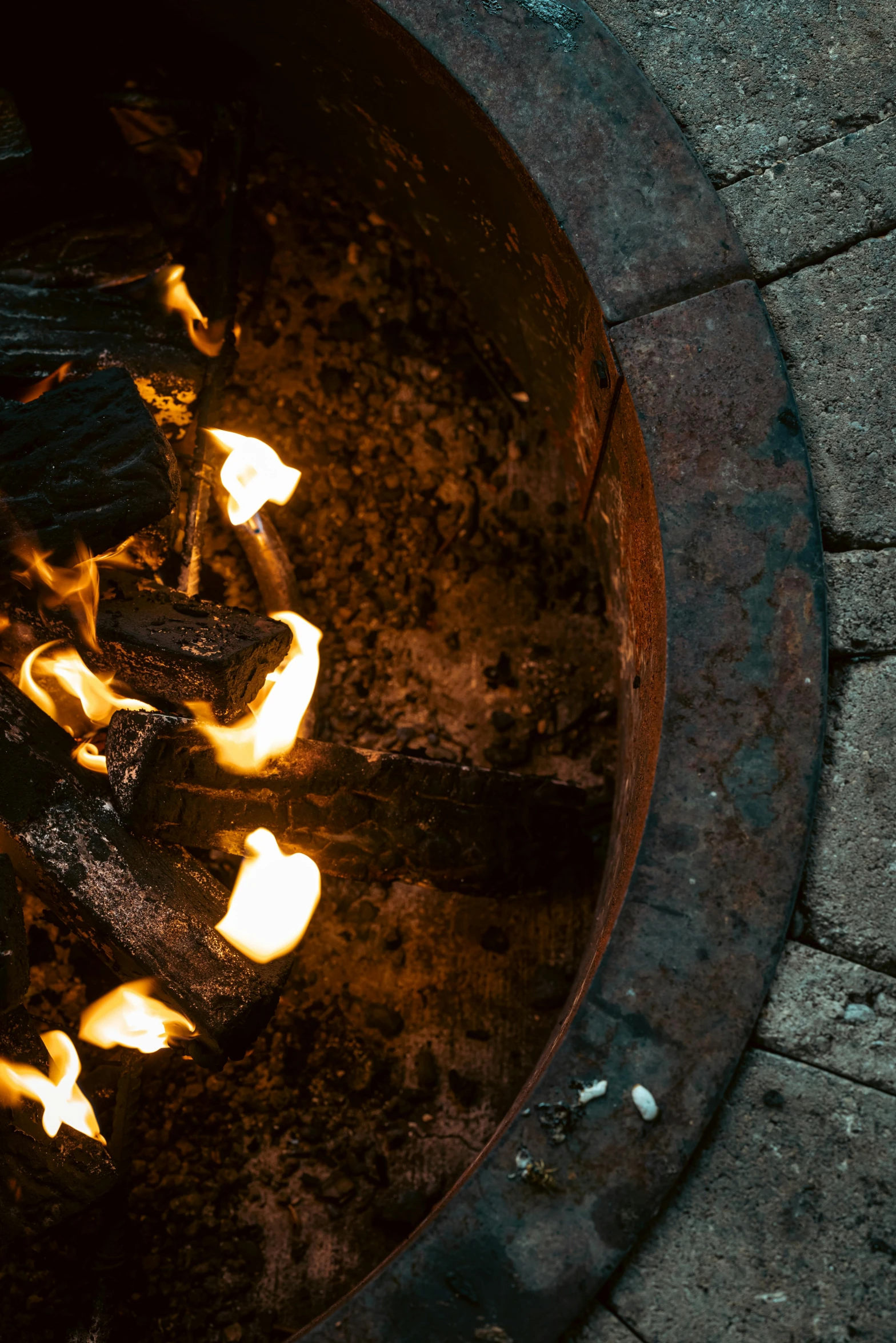 a bbq grill filled with flames and sticks