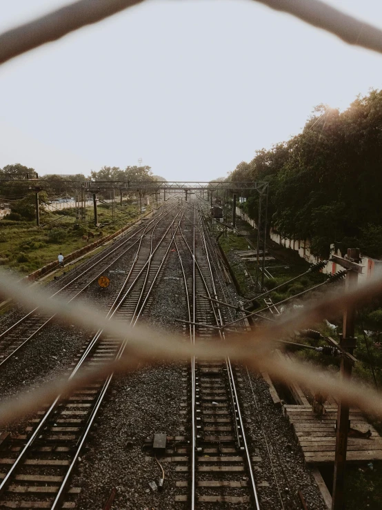 a view of a train track through a chain link fence, pexels contest winner, assamese aesthetic, instagram story, alternate album cover, transparent background