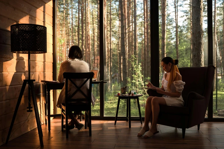 there are two woman sitting on chairs in this room