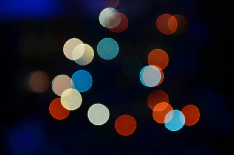 a close up of a cell phone with a blurry background, by Jan Rustem, pexels, generative art, blue and orange rim lights, varying dots, christmas lights, circles