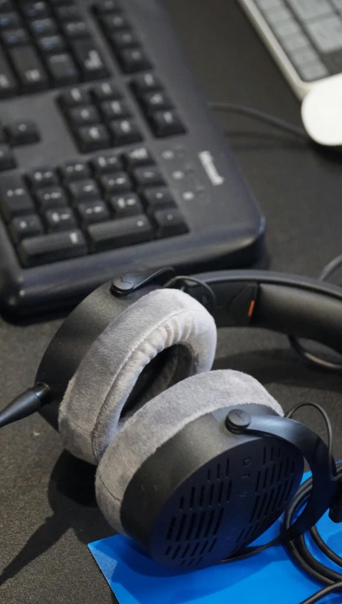 a pair of headphones sitting on top of a desk next to a keyboard, featured on reddit, hurufiyya, mixed materials, creating a soft, round-cropped, steam workshop