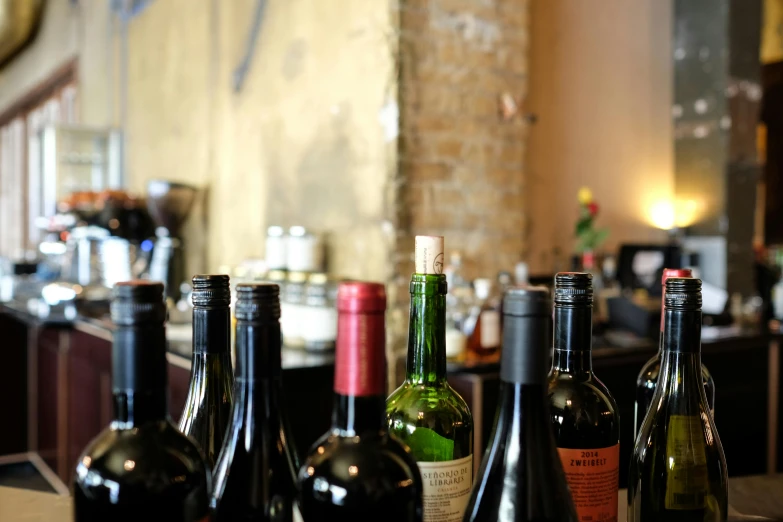 a row of wine bottles sitting on top of a counter, pexels contest winner, long table, thumbnail, back room, impasto