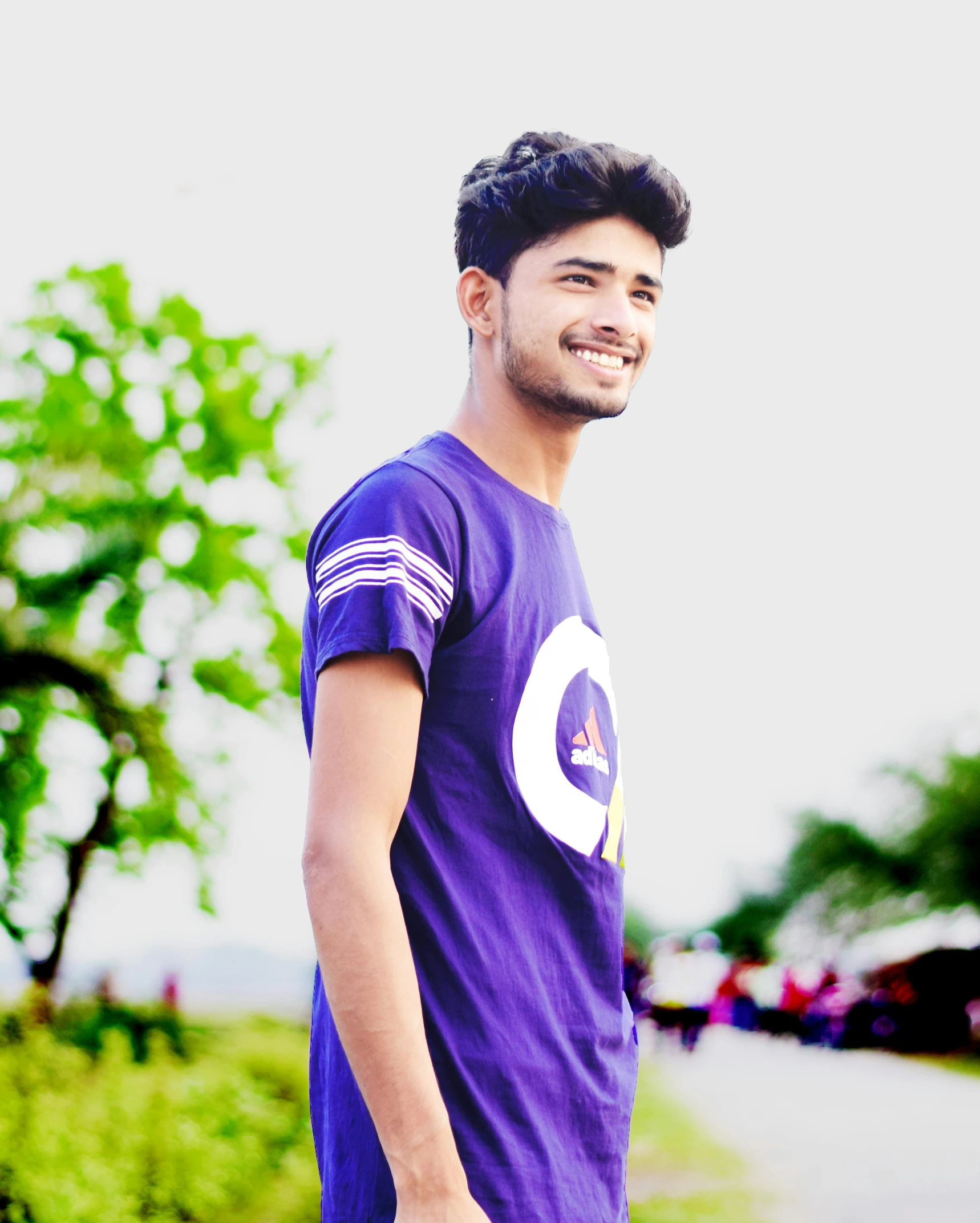 a man with a purple shirt stands on the street