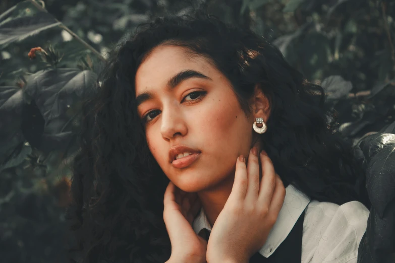 a woman with long black hair posing for a picture, by irakli nadar, trending on pexels, an earring, mixed race, with a round face, white curly hair