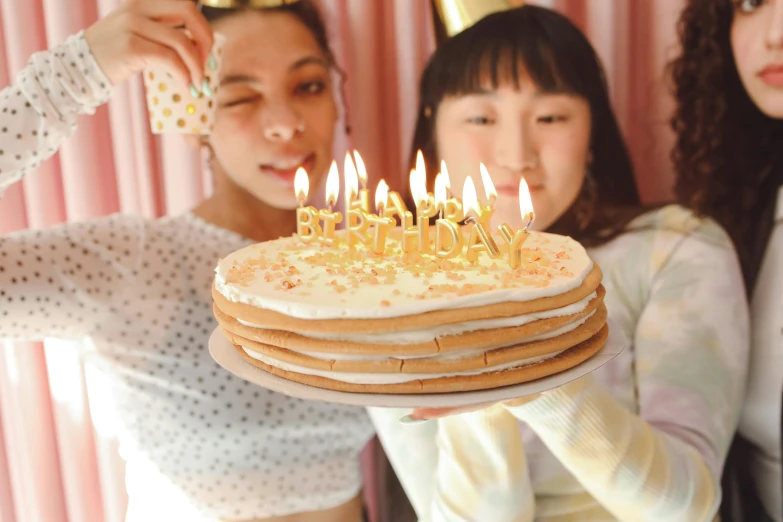 a group of women holding a cake with lit candles, an album cover, pexels, japanese, pancake flat head, background image, at a birthday party