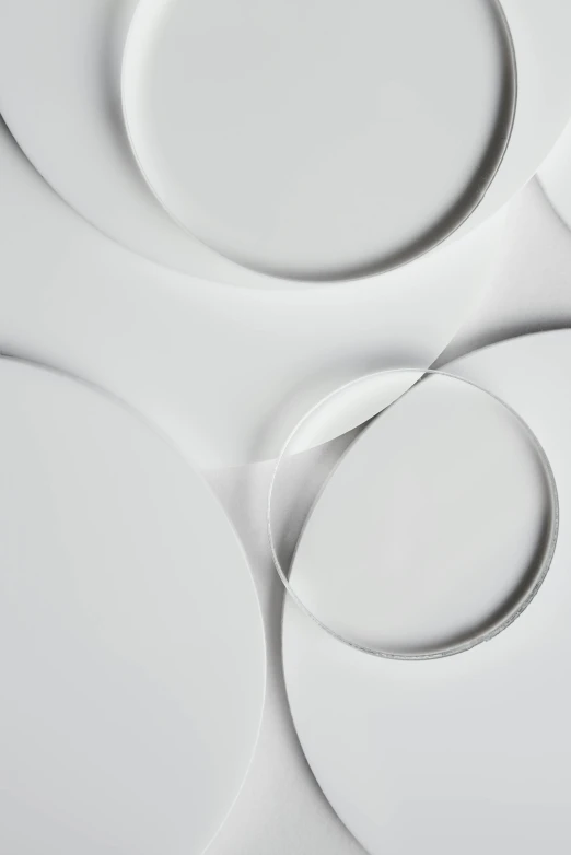 a group of white plates sitting on top of a table, inspired by Anish Kapoor, trending on pexels, abstract detail, orbital rings, detail shot, made of high tech materials