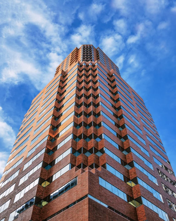 a tall brick building with a blue sky in the background, by Tom Phillips, pexels contest winner, cascading highrise, capital plaza, thumbnail, james turrell building