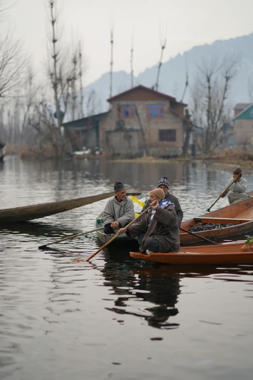 a couple of people riding on top of a boat, hurufiyya, in a lake, trending on national geographic, slide show, winter season