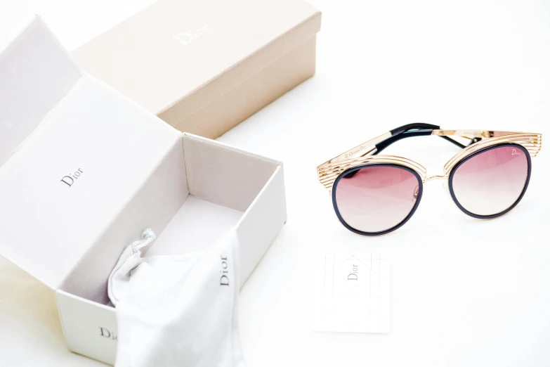 a pair of sunglasses sitting inside of a box, dada, gold details, on a white table, dior, thumbnail