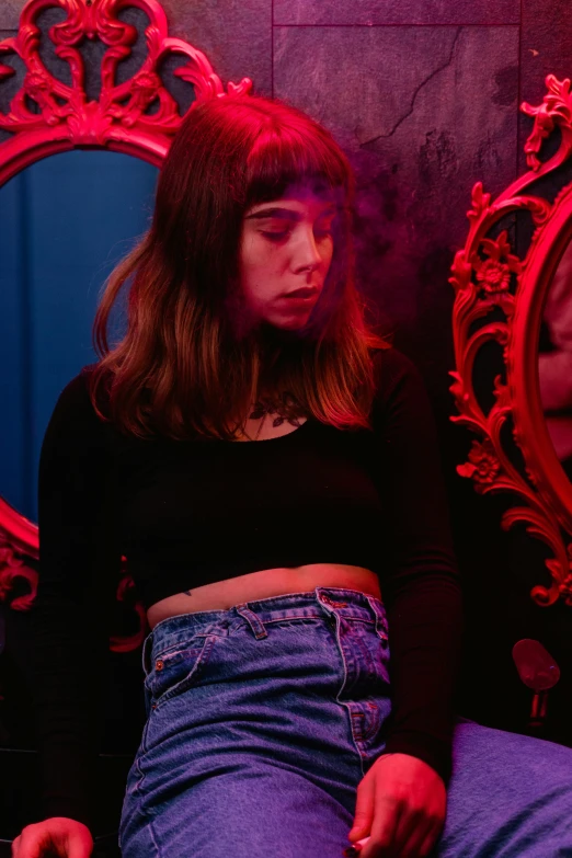 a woman sitting in front of a mirror, an album cover, inspired by Elsa Bleda, realism, full bangs, cinematic red lighting, mall goth, ( ( emma lindstrom ) )