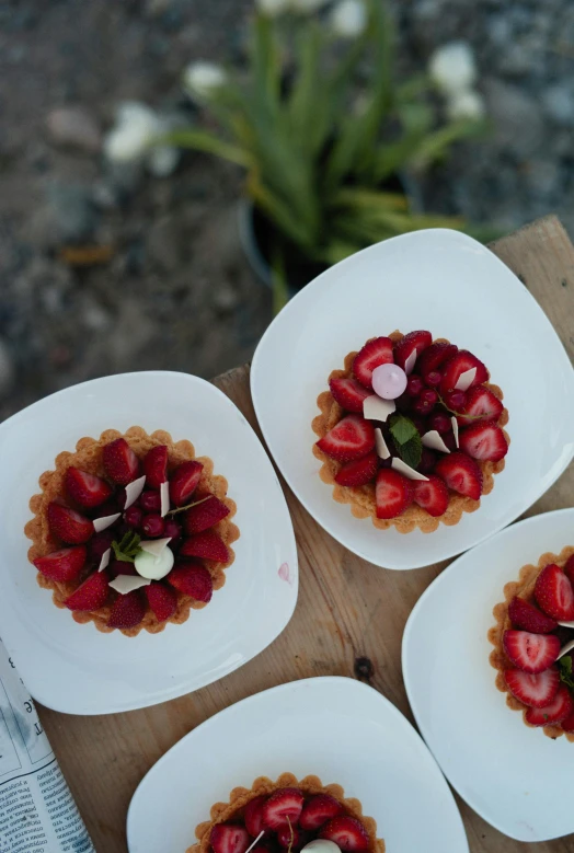 a close up of four plates of food on a table, strawberry, desserts, resort, day time