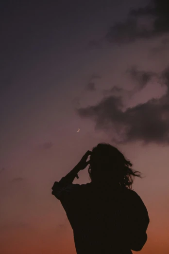 a woman standing on top of a beach next to the ocean, an album cover, trending on pexels, aestheticism, moon backlight, ✨🕌🌙, pastel palette silhouette, men look up at the sky