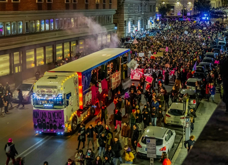 a crowd of people gathered next to two buses