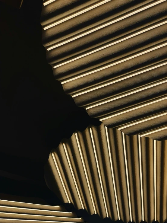 a close up of a ceiling with a clock on it, inspired by Pierre Soulages, unsplash, golden light film grain, folded geometry, cardboard, dramatic lighting - n 9