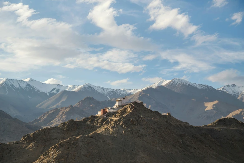 there are many mountains in the distance with white clouds