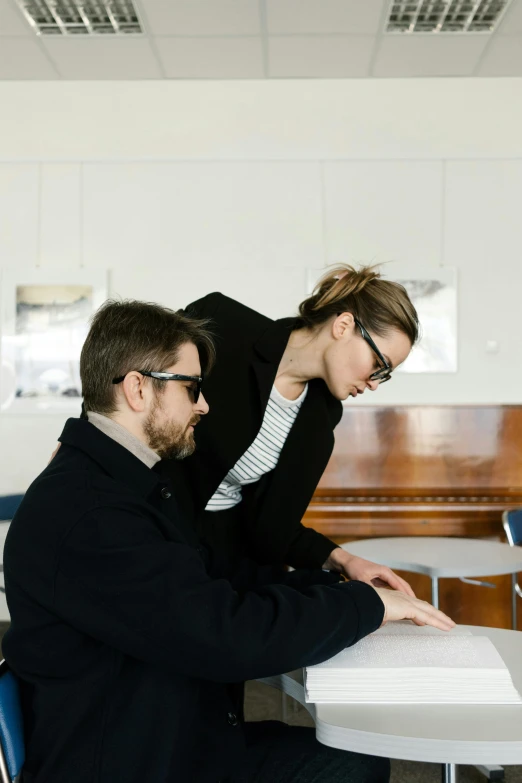 a man and a woman sitting at a table, by Nina Hamnett, unsplash, visual art, wearing black frame glasses, standing on a desk, teaching, profile image