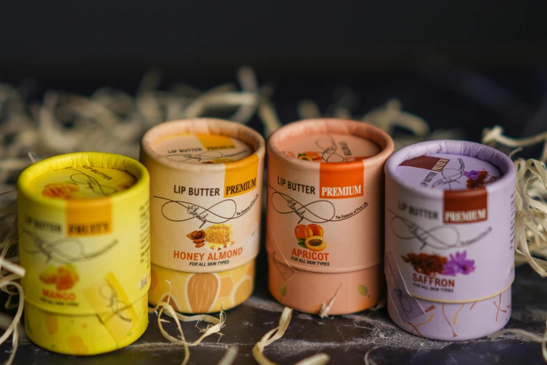 a group of tins sitting on top of a pile of hay, warmer and softer colours, detailed product shot, lips, honey