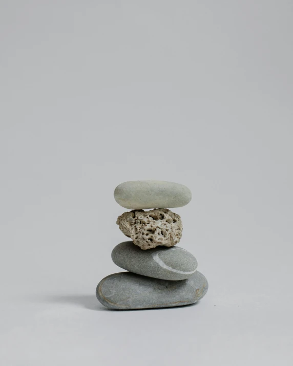 a stack of rocks sitting on top of each other, unsplash, minimalism, detailed product image, on a gray background, petite, made of cement