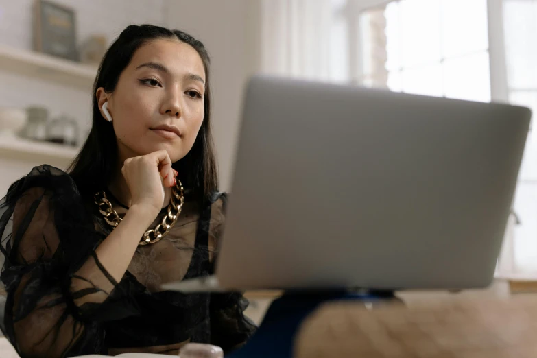 a woman sitting in front of a laptop computer, trending on pexels, gemma chan, serious business, black jewellery, asian descent