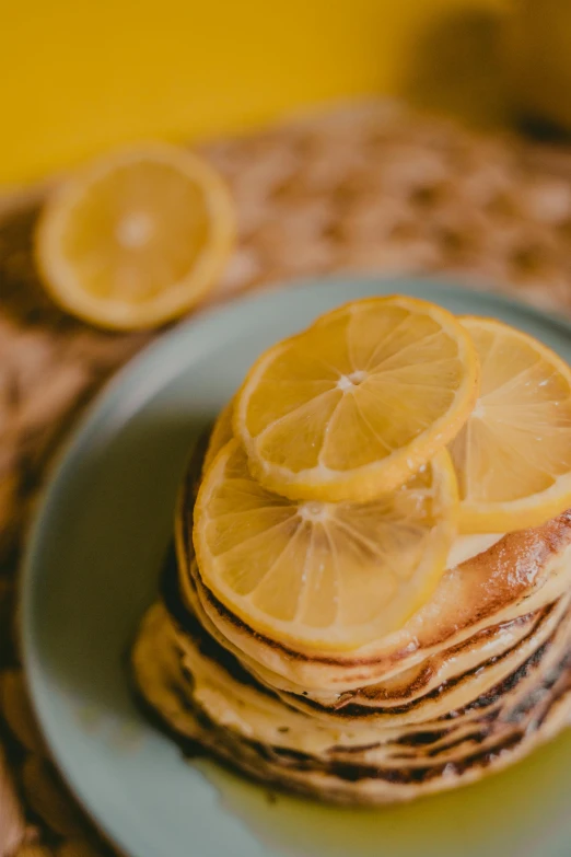 a stack of pancakes topped with lemon slices, a still life, trending on pexels, made of glazed, half image, seasonal, full faced