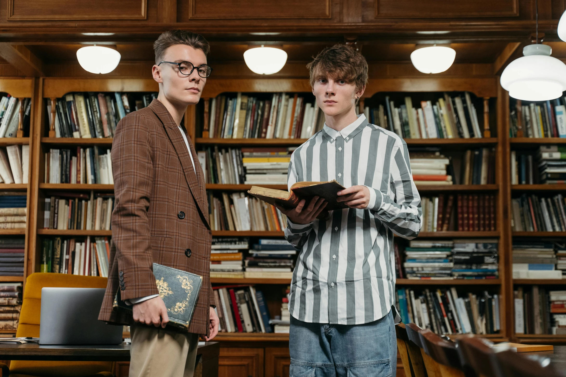 two men standing next to each other in a library, by Carey Morris, pexels, academic art, vitalik buterin, conservatively dressed, lachlan bailey, promo still